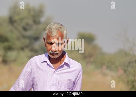 Gros plan Photographie d'un homme âgé résidant en Inde ou d'un agriculteur âgé autonome ayant un arrière-plan défoqué de la nature ou de la forêt Banque D'Images