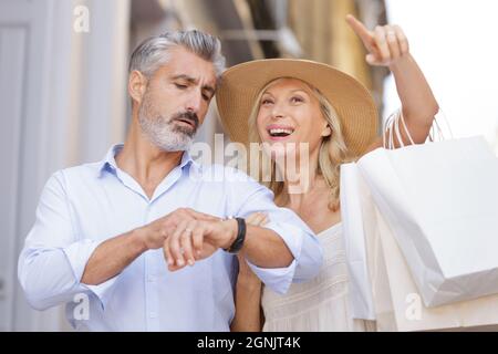 heureux couple d'âge mûr marchant avec leurs achats Banque D'Images