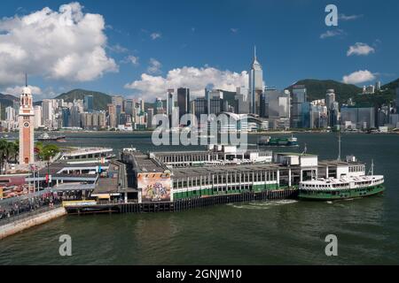 Un Star Ferry quitte l'embarcadère Tsim Sha Tsui à Kowloon, avec WAN Chai et Causeway Bay, sur l'île de Hong Kong, visible de l'autre côté du port de Victoria Banque D'Images