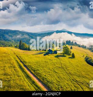 Photographie aérienne de paysage. Ancienne maison en bois sur la vallée de la montagne. Scène estivale spectaculaire d'un village carpalien abandonné. Magnifique cache-terre le matin Banque D'Images