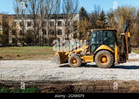 Dneprorata,Ukraine - avril 08 2020 : un tracteur verse le gravier du godet Banque D'Images