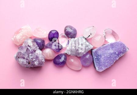 De belles pierres précieuses et des drases d'améthyste minéral violet naturel sur fond rose. Améthystes et quartz rose. Grands cristaux de sto semi-précieux Banque D'Images