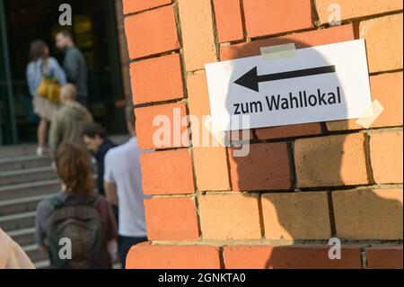 Berlin, Allemagne. 26 septembre 2021. Les électeurs se tiennent devant un bureau de vote dans la dernière heure avant la fermeture des bureaux de vote, tandis que sur un mur en face de celui-ci, l'ombre d'un homme tombe sur un morceau de papier avec les mots « au bureau de vote ». L'élection fédérale de 2021 aura lieu le 26 septembre. Credit: Sebastian Gollnow/dpa/Alay Live News Banque D'Images