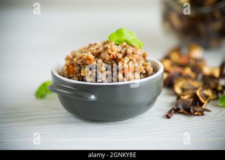 sarrasin bouilli avec légumes et champignons de la forêt séchés dans un moule en céramique Banque D'Images