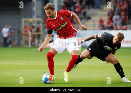 Freiburg im Breisgau, Allemagne. 26 septembre 2021. Football: Bundesliga, SC Freiburg - FC Augsbourg, Matchday 6, Dreisamstadion: Lucas Höler de Fribourg (l) dans un duel avec Niklas Dorsch d'Augsbourg. Credit: Philipp von Ditfurth/dpa - NOTE IMPORTANTE: Conformément aux règlements de la DFL Deutsche Fußball Liga et/ou de la DFB Deutscher Fußball-Bund, il est interdit d'utiliser ou d'avoir utilisé des photos prises dans le stade et/ou du match sous forme de séquences et/ou de séries de photos de type vidéo./dpa/Alay Live News Banque D'Images