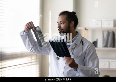 Un jeune médecin afro-américain sérieux examine des films de dépistage par radiographie Banque D'Images