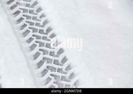 Les traces de pneus de voiture dans la neige fraîche sur la route. Chute de neige Banque D'Images