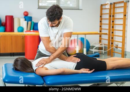 Mains du physiothérapeute faisant un massage médical du dos, à une patiente, pendant un traitement de réadaptation. Banque D'Images