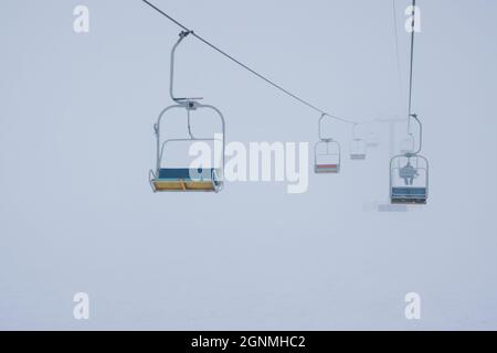 Les téléphériques pendent les câbles dans un brouillard silencieux Banque D'Images