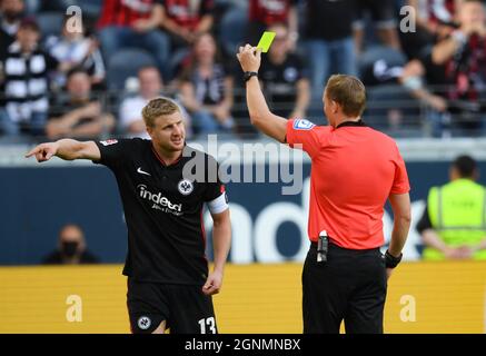 25 septembre 2021, Hessen, Francfort-sur-le-main: Football: Bundesliga, Eintracht Frankfurt - 1. FC Köln, Matchday 6 au Deutsche Bank Park. L'arbitre Martin Petersen (r) montre le carton jaune Martin Hinteregger de Francfort. Photo: Arne Dedert/dpa - NOTE IMPORTANTE: Conformément aux règlements de la DFL Deutsche Fußball Liga et/ou de la DFB Deutscher Fußball-Bund, il est interdit d'utiliser ou d'avoir utilisé des photos prises dans le stade et/ou du match sous forme de séquences et/ou de séries de photos de type vidéo. Banque D'Images