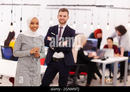 Deux collègues multiethniques dans un espace de bureau moderne. Groupe de personnes travaillant en arrière-plan concept de diversité et de réussite. Banque D'Images