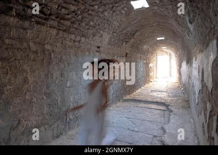 Bergama, Izmir, Turquie. 26 septembre 2021. Asklepion est un ancien complexe de guérison situé à la base de l'acropole de Pergame en Turquie, construit en l'honneur d'Asklepios, dieu de guérison. Une femme touristique posant et courant dans un couloir de l'ancien complexe pour créer et l'humeur ancienne pour la photo. (Image de crédit : © Uygar Ozel/ZUMA Press Wire) Banque D'Images