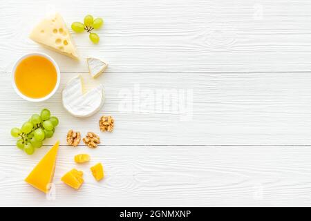 Divers types de fromage avec miel et raisins. Vue de dessus de la pose à plat Banque D'Images
