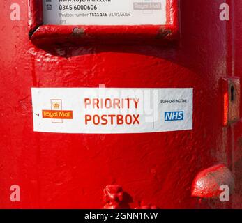 Une boîte postale traditionnelle de Royal Mail dans un petit village appelé Prority Postbox 'Sporting the NHS' dans le nord du Yorkshire, Angleterre, Royaume-Uni Banque D'Images