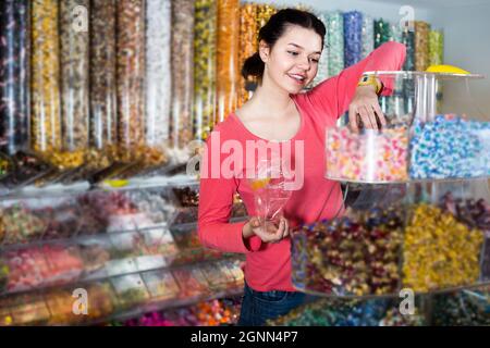 Une fille américaine en magasin vient chercher des bonbons Banque D'Images