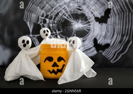 Un petit fantôme épouse le symbole halloween sur fond de toiles d'araignée et de chauves-souris. Concept de halloween . Banque D'Images