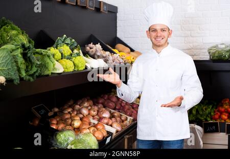Homme cuisinier décidant des meilleurs légumes Banque D'Images