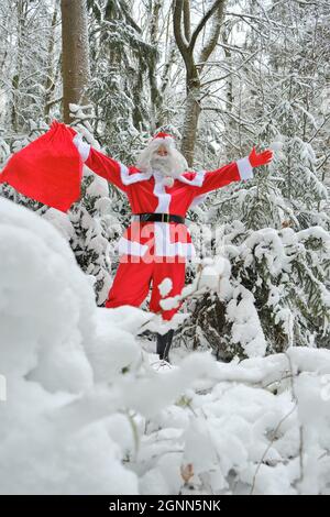 Le Père Noël et un grand sac de cadeaux dans la forêt enneigée.Joyeux Noël. Noël et nouvel an Banque D'Images