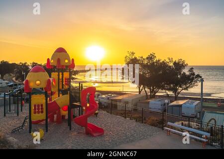 Moonta Bay, Australie méridionale - 26 octobre 2019 : terrain de jeu pour enfants dans le parc de mobil-home Moonta Bay au coucher du soleil, vue sur la côte Banque D'Images