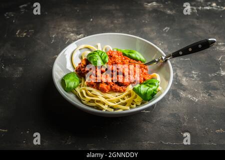 Pâtes traditionnelles bolognaise avec du bœuf et des tomates le fond rustique. Mise au point sélective. Banque D'Images