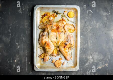 Poulet grillé sur la poêle avec des épices, de l'ail, du thym et des tranches de citron.Mise au point sélective.Faible profondeur de champ. Banque D'Images