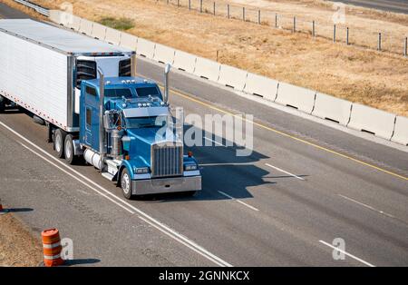Capot classique bleu industriel semi-remorque American idol Big avec tuyaux d'échappement chromés transportant des marchandises commerciales congelées dans une semi-remorque reefer Banque D'Images