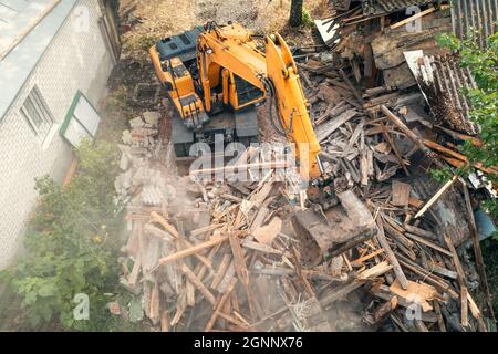 Processus de démolition de l'ancien bâtiment de démantèlement. Carter de rupture de pelle hydraulique. Destruction de logements délabrés pour un nouveau développement. Banque D'Images