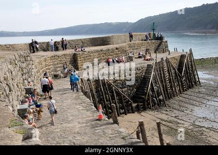 Clovelly mur de port en deux niveaux avec des visiteurs à marée basse et vieux poteaux d'amarrage et des marches d'accès North Devon Banque D'Images