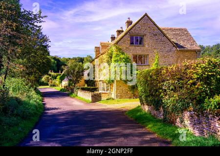 Cottages traditionnels en pierre construits le long d'une ruelle de campagne dans le joli village Cotswold Cotswolds de Upper Slaughter Gloucestershire Angleterre Royaume-Uni Banque D'Images