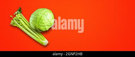 Bouquet de branche de céleri et chou vert isolé sur fond de bannière rouge. Vue de dessus Banque D'Images