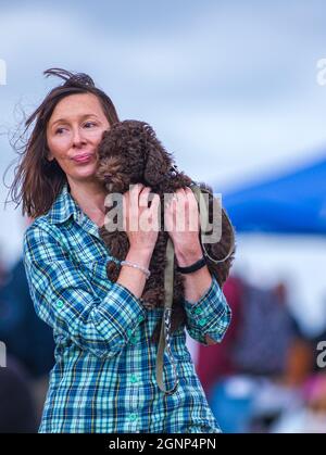 Un portrait d'une femme portant son petit chien s'est assis sur son épaule Banque D'Images