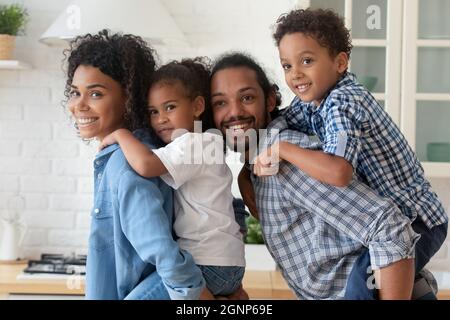 Portrait heureux parents afro-américains qui soutiennent deux enfants Banque D'Images