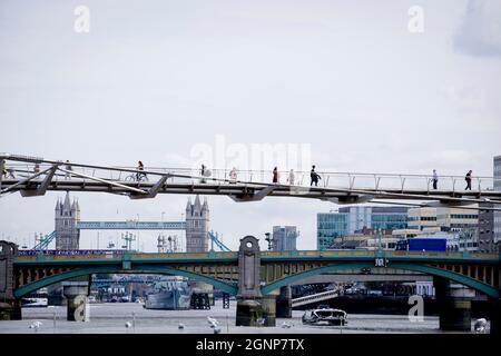 Avec Tower Bridge à distance et le Southwark Bridge plus vert, les Londoniens traversent le Millennium Bridge au-dessus de la Tamise, le 13 septembre 2021, à Londres, en Angleterre. La plus récente traversée de la rivière de Londres depuis plus de 100 ans a coïncidé avec le Millenium en 2000. Elle a été achevée à la hâte et ouverte au public le 10 juin 2000, quand environ 100,000 personnes l'ont traversée pour découvrir que la structure oscille tellement qu'elle a été forcée de fermer 2 jours plus tard. Au cours des 18 prochains mois, les concepteurs ont ajouté des amortisseurs pour arrêter sa vacillement, mais il symbolisait déjà ce qui était embarrassant et qui m'a manqué Banque D'Images