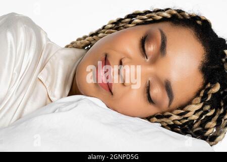 gros plan de la jeune femme afro-américaine avec des dreadlocks dormant isolés sur blanc Banque D'Images