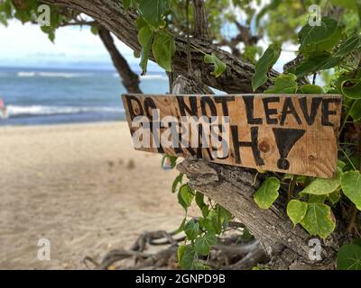 Gros plan sur un panneau peint à la main à la plage d'Oahu rappelant aux amateurs de plage de prendre leurs déchets Banque D'Images