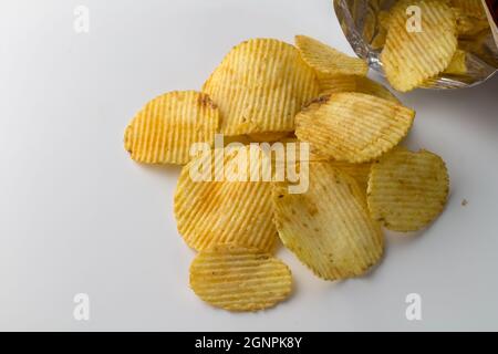 Tas de chips de pommes de terre scintillantes isolées sur fond blanc avec espace de texte Banque D'Images