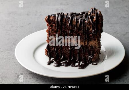 Assiette avec tranche de délicieux gâteau au chocolat maison sur table grise Banque D'Images