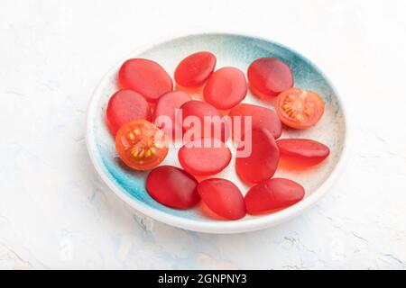 Bonbons de tomates en gelée sur fond de béton blanc. Vue latérale, gros plan. Banque D'Images