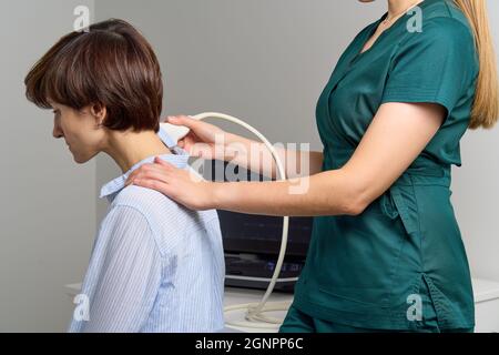 Échographiste féminine sans visage qui examine le cou. Professionnel de la santé qui effectue l'échographie Banque D'Images