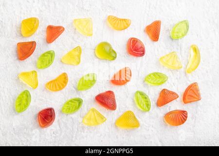 Plusieurs bonbons en gelée de fruits sur fond de béton gris. Vue de dessus, plat, gros plan. Banque D'Images