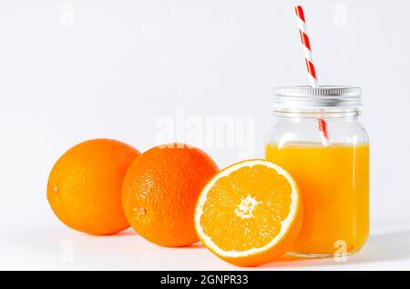 Jus d'orange dans un gobelet fermé avec un tube et une tranche d'orange isolée sur du blanc. Bol en verre avec tube et jus d'orange fraîchement pressé Banque D'Images