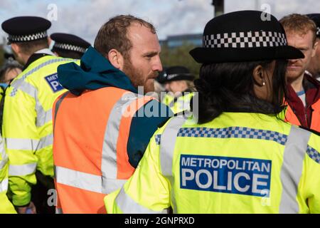 Colnbrook, Royaume-Uni. 27 septembre 2021. Le porte-parole d'Isolate Britain Liam Norton est arrêté après qu'une route de la M25 à la jonction 14 près de Heathrow a été bloquée par Isolate Britain dans le cadre d'une campagne visant à pousser le gouvernement britannique à apporter des modifications législatives significatives pour commencer à réduire les émissions. Crédit : Mark Kerrison/Alamy Live News Banque D'Images