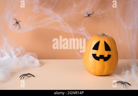 Citrouille d'Halloween avec toiles d'araignée sur fond orange. Concept créatif Halloween minimal. Espace pour le texte Banque D'Images