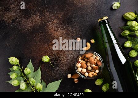 bouteille de bière fraîche, encas et houblon vert sur fond de grunge Banque D'Images