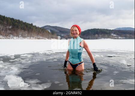 Portrait d'une femme âgée active en maillot de bain à l'extérieur en hiver, concept de thérapie froide. Banque D'Images