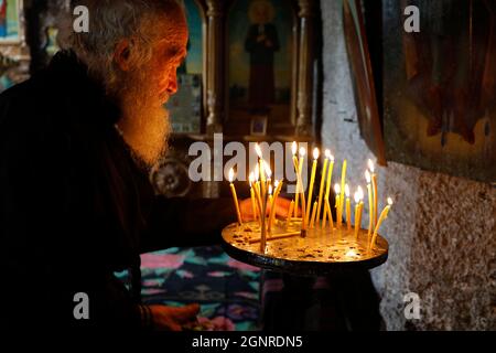 Monk timourant des bougies dans le monastère Orhei Vecchi, Moldavie Banque D'Images