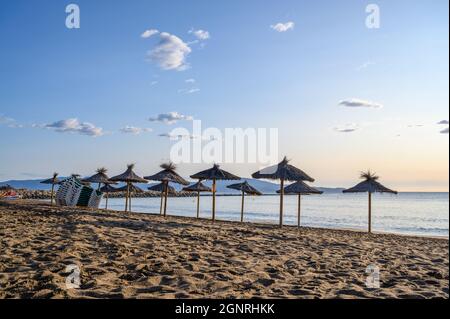 L'Escala catalogne Espagne juillet 22 2019 parasols en osier et chaises longues à louer sur la plage Banque D'Images