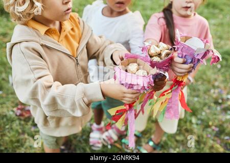 Gros plan des enfants tenant des bonbons de la pinata pendant la fête d'anniversaire à l'extérieur, espace de copie Banque D'Images