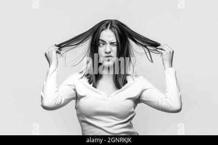 Femme frustrée ayant de mauvais cheveux. Femme ayant un mauvais cheveux, ses cheveux sont désordonnés et emmêlés. Cheveux salissants. Brunette femme aux poils disgracieux. Fille ayant Banque D'Images