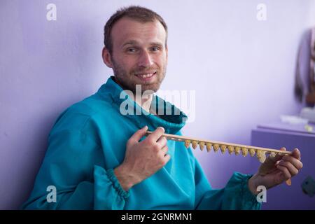 le apiculteur tient une plaque avec de grandes cellules. Cellule Queen apicole pour les larves des abeilles Queen. Banque D'Images